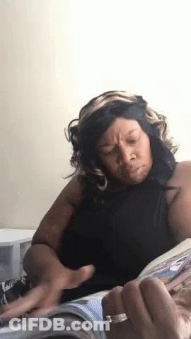 A Woman Is Reading A Magazine And Making A Face GIF