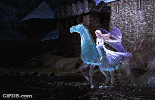A Woman Is Riding On The Back Of A Blue Horse In Front Of A Castle GIF