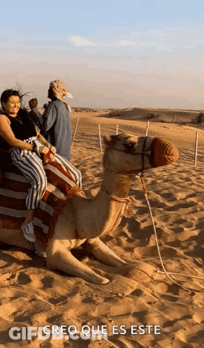 A Woman Is Riding On The Back Of A Camel In The Desert With The Caption Creo Que Es Este GIF