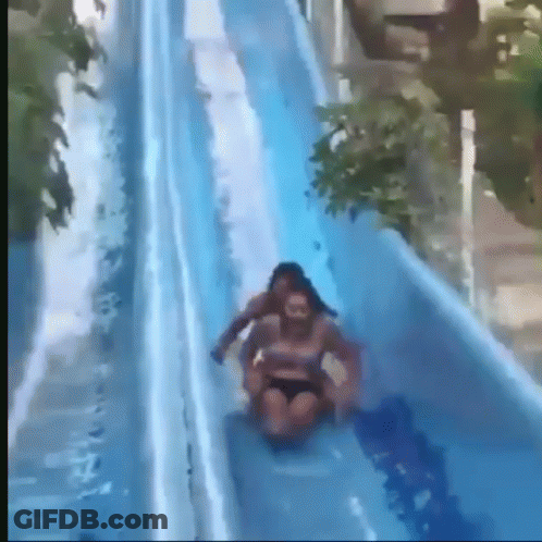 A Woman Is Riding On The Back Of A Man On A Water Slide GIF