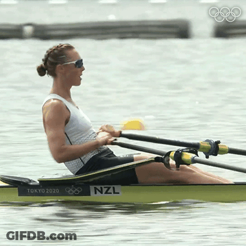 A Woman Is Rowing A Boat With The Letters Nzl On The Side GIF