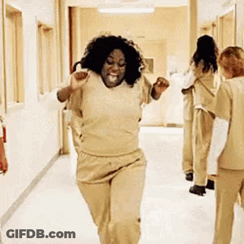 A Woman Is Running Down A Hallway In A Hospital While A Group Of Women Are Standing Behind Her . GIF