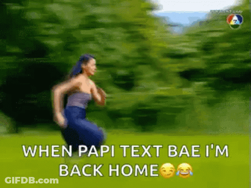 A Woman Is Running In A Field With The Words `` When Papi Text Bae I 'M Back Home '' Written On It . GIF