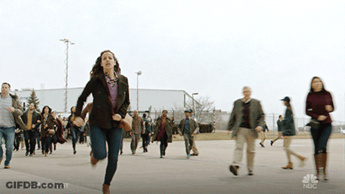 A Woman Is Running In Front Of A Crowd With The Hashtag #Manifest On The Bottom GIF