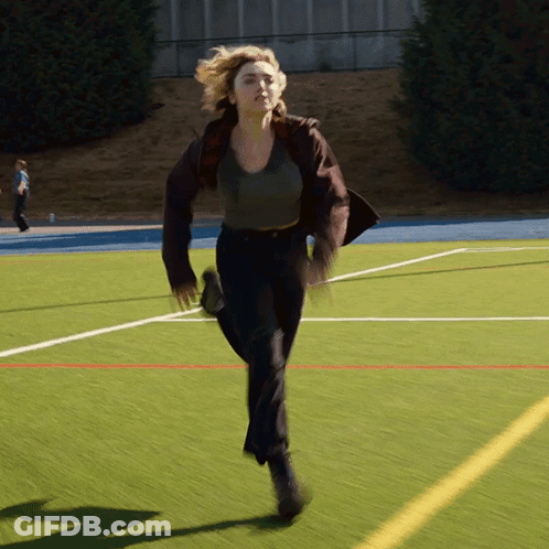 A Woman Is Running On A Field With A Yellow Line GIF