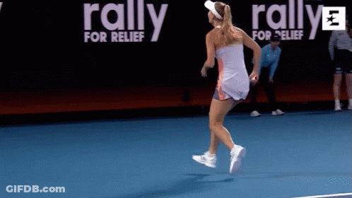 A Woman Is Running On A Tennis Court With A Rally For Relief Banner Behind Her GIF