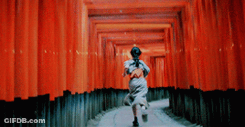 A Woman Is Running Through A Tunnel Of Red Walls GIF