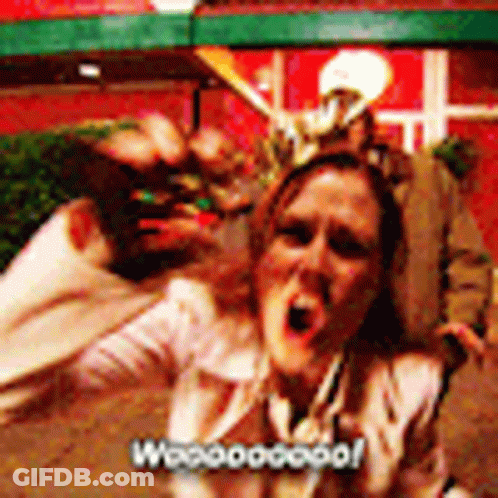 A Woman Is Screaming In Front Of A Group Of People And The Words Woooogood Are On The Bottom Right GIF