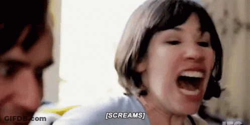 A Woman Is Screaming In Front Of A Man While Sitting Next To Him . GIF