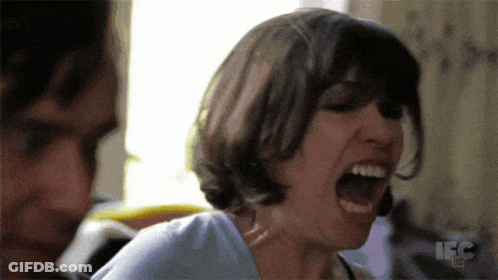 A Woman Is Screaming In Front Of A Man With The Letters Ifc On The Bottom Right GIF
