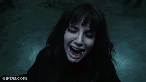 A Woman Is Screaming In The Dark With Her Mouth Wide Open GIF
