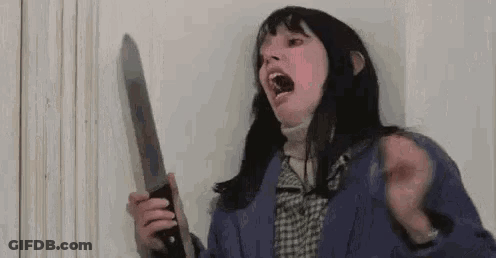 A Woman Is Screaming While Holding A Large Knife In Her Hand . GIF
