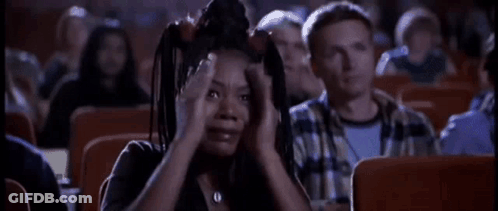 A Woman Is Screaming While Sitting In A Theater . GIF