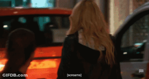 A Woman Is Screaming While Standing Next To A Car GIF