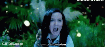 A Woman Is Singing I Am A Champion In Front Of A Green Background . GIF