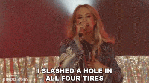 A Woman Is Singing Into A Microphone And Saying `` I Slashed A Hole In All Four Tires '' GIF