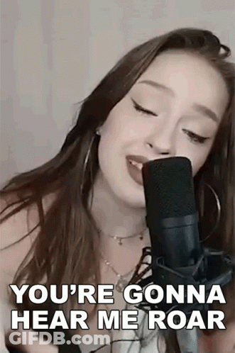 A Woman Is Singing Into A Microphone And Saying You 'Re Gonna Hear Me Roar . GIF