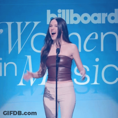 Woman Singing Into Microphone In Front Of Billboard GIF