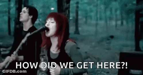 A Woman Is Singing Into A Microphone While A Man Plays A Guitar In A Band . GIF