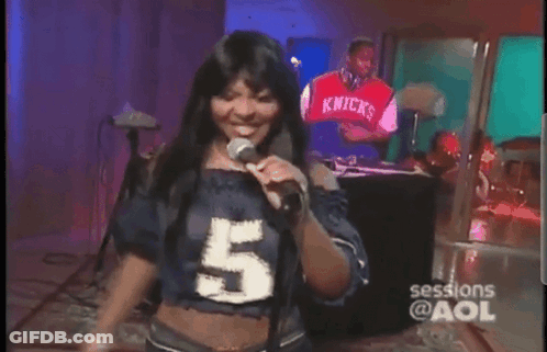 A Woman Is Singing Into A Microphone While Wearing A Number 5 Shirt GIF