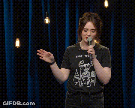 A Woman Is Singing Into A Microphone While Wearing A T-Shirt That Says Choose . GIF