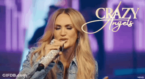 A Woman Is Singing Into A Microphone With The Words Crazy Angels Written On The Bottom GIF