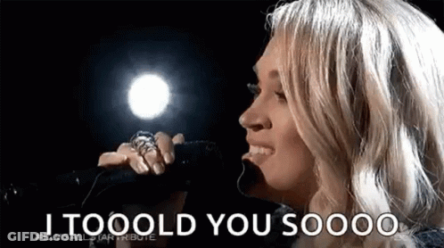A Woman Is Singing Into A Microphone With The Words `` I Tooold You Soooo '' . GIF