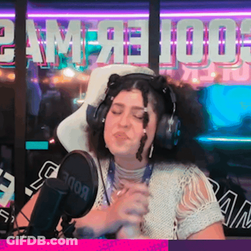 A Woman Is Singing Into A Rode Microphone In Front Of A Sign That Says Game 100 GIF
