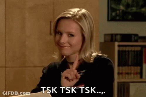 A Woman Is Sitting At A Desk And Pointing At Something . GIF