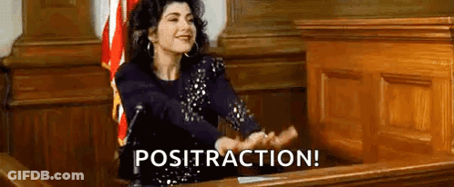 A Woman Is Sitting At A Desk In A Courtroom With Her Hands Outstretched And The Words Posttraction Written Above Her . GIF