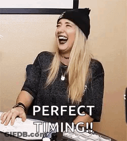 A Woman Is Sitting At A Desk Laughing While Using A Computer Keyboard . GIF