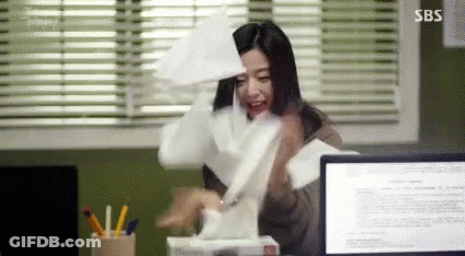 A Woman Is Sitting At A Desk With A Box Of Tissues In Front Of A Computer . GIF