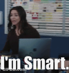 A Woman Is Sitting At A Desk With A Laptop And The Words I 'M Smart Behind Her GIF