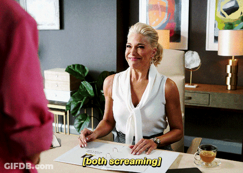 A Woman Is Sitting At A Desk With The Words Both Screaming Written Above Her GIF