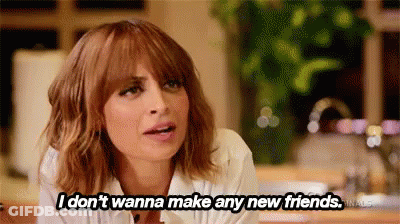 A Woman Is Sitting At A Table And Saying `` I Don 'T Wanna Make Any New Friends . '' GIF