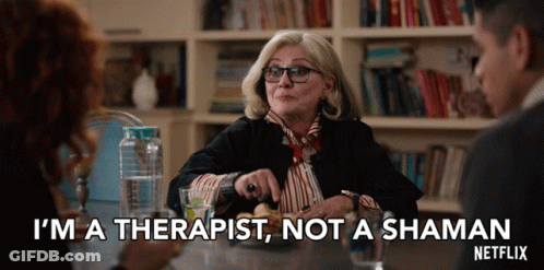 A Woman Is Sitting At A Table And Says I 'M A Therapist Not A Shaman GIF