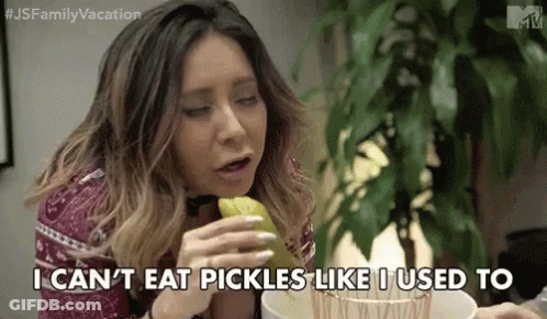 A Woman Is Sitting At A Table Eating Pickles And Saying `` I Can 'T Eat Pickles Like I Used To '' GIF