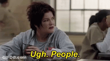 A Woman Is Sitting At A Table In A Prison Cell Holding A Cup Of Coffee And Saying Ugh . People . GIF