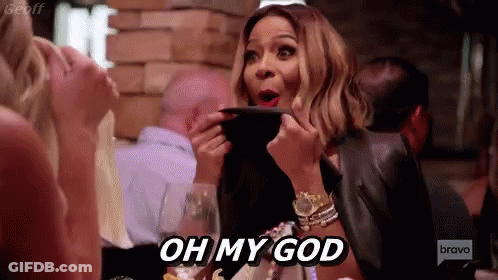 A Woman Is Sitting At A Table In A Restaurant Holding A Plate And Saying Oh My God . GIF