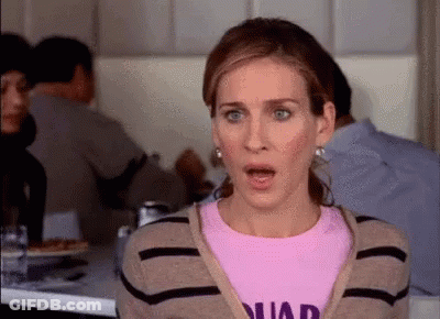 A Woman Is Sitting At A Table In A Restaurant With Her Mouth Open And A Surprised Look On Her Face . GIF