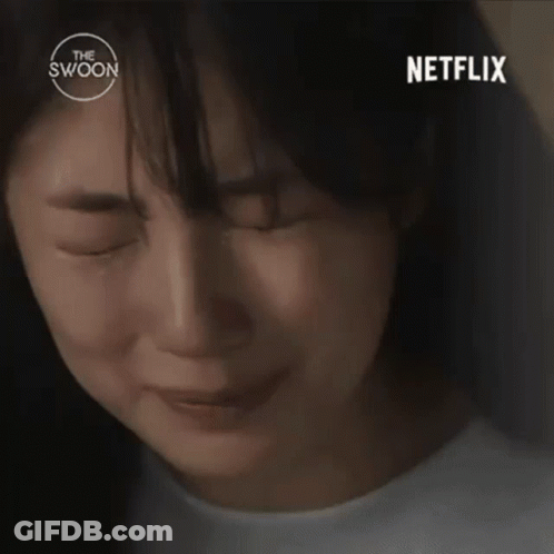 A Woman Is Sitting At A Table In Front Of A Bookshelf And A Netflix Logo . GIF