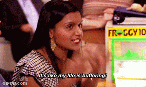 A Woman Is Sitting At A Table In Front Of A Machine That Says `` It 'S Like My Life Is Buffering '' . GIF