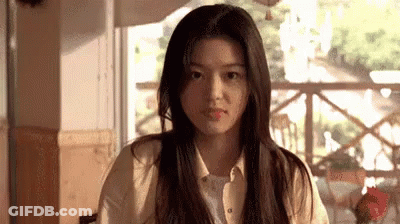 A Woman Is Sitting At A Table In Front Of A Window In A Restaurant . GIF