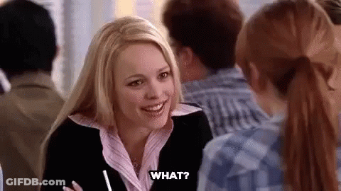 A Woman Is Sitting At A Table Talking To A Group Of People And Smiling . GIF