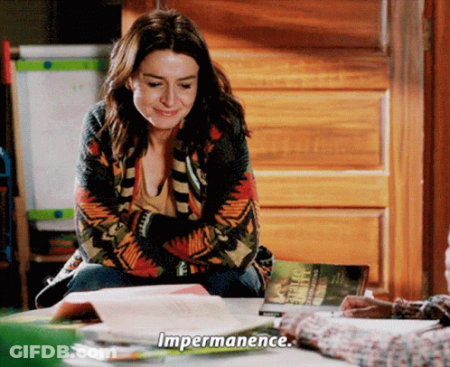 A Woman Is Sitting At A Table With A Book And Says Impermanence GIF