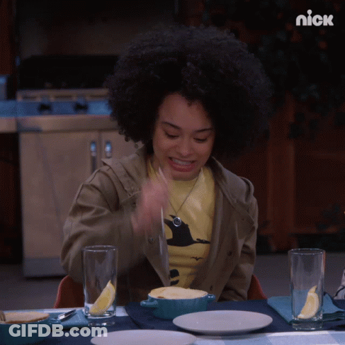 A Woman Is Sitting At A Table With A Bowl Of Food And A Nick Logo On The Bottom GIF