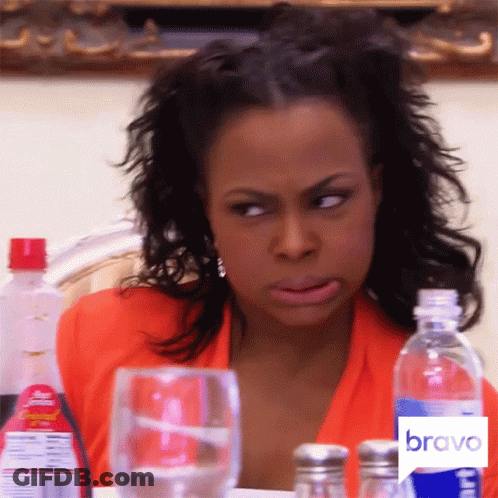 A Woman Is Sitting At A Table With A Bravo Logo On The Bottom GIF