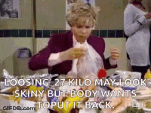 A Woman Is Sitting At A Table With A Bunch Of Food And A Bag Of Food . GIF