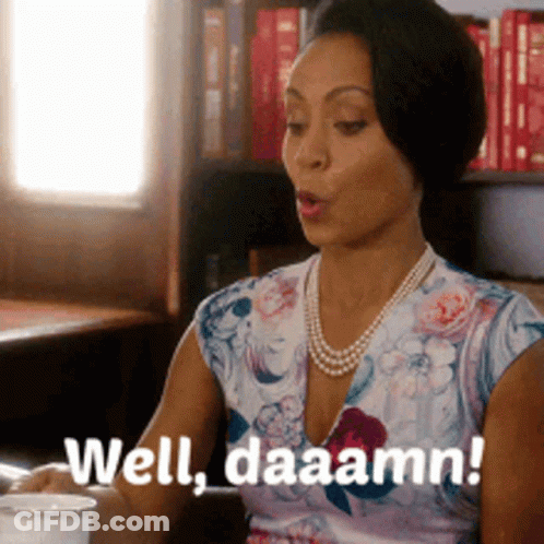 A Woman Is Sitting At A Table With A Cup Of Coffee And Says Well Daaamn ! GIF