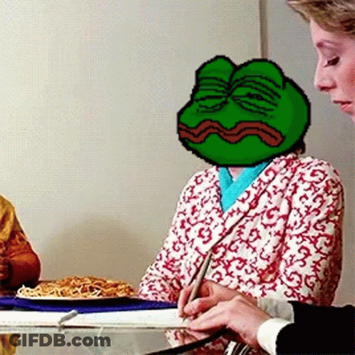 A Woman Is Sitting At A Table With A Frog On Her Head GIF